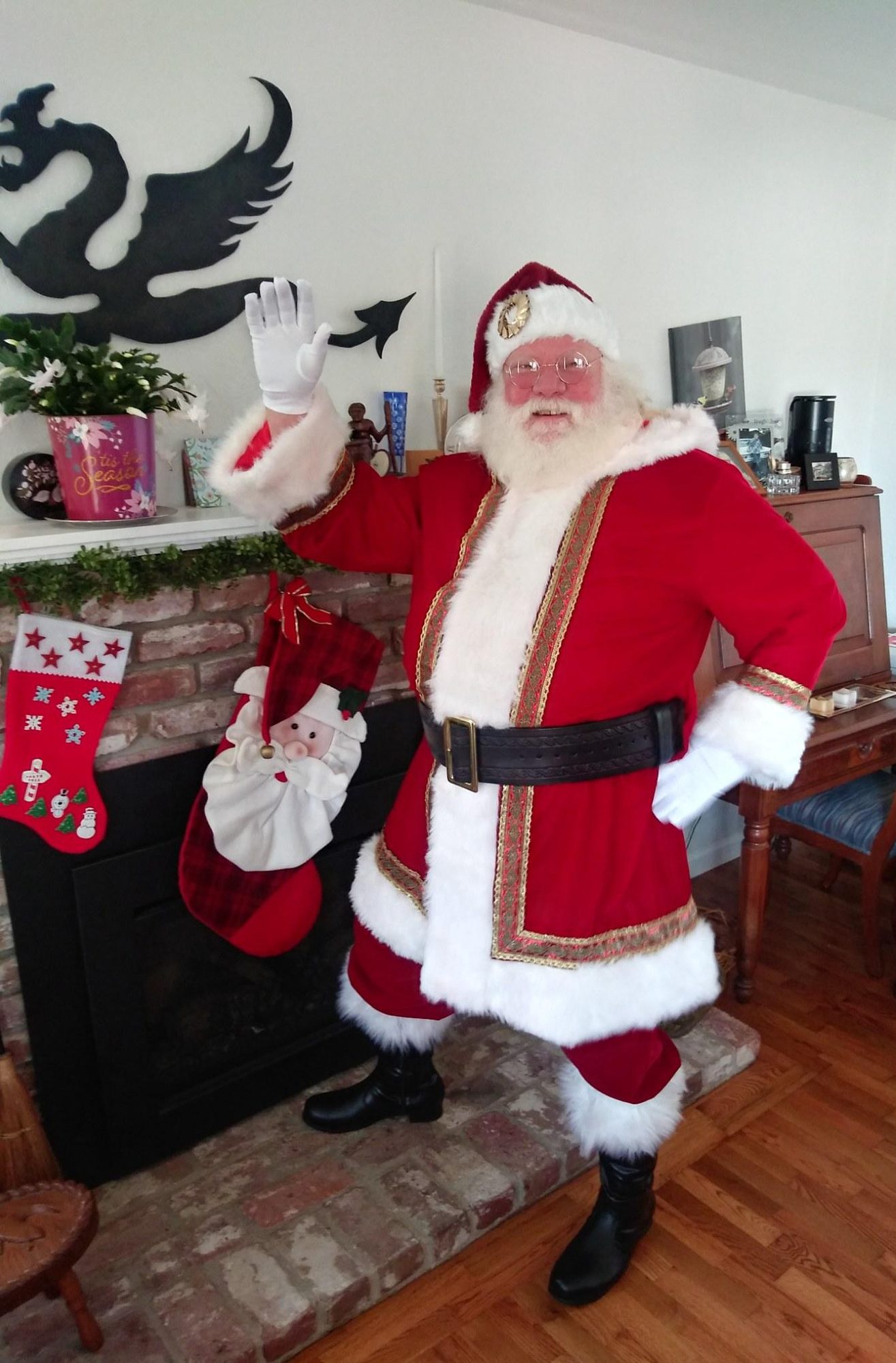 Santa Claus waving by the fireplace
