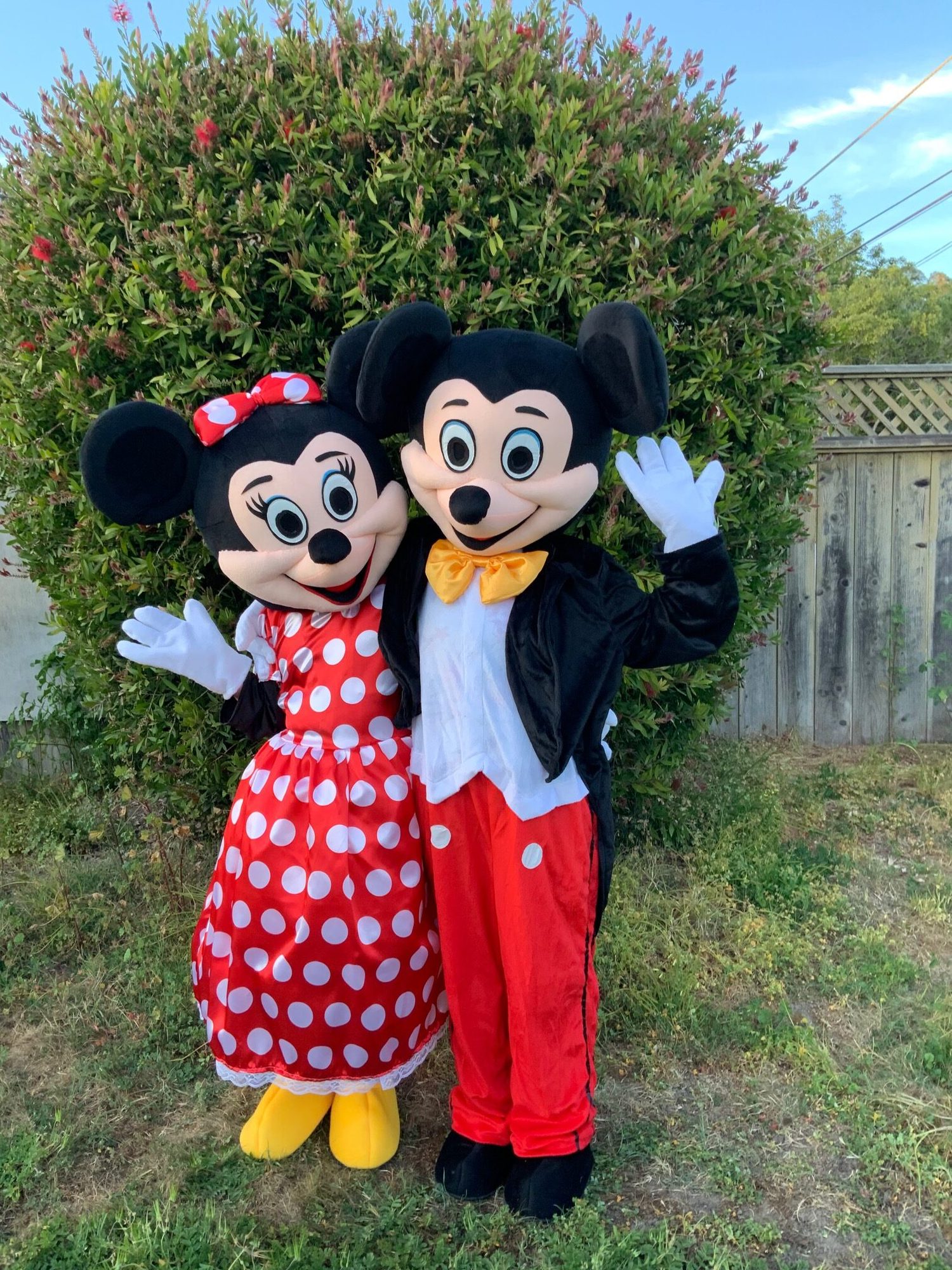 A costume character duo waving hello