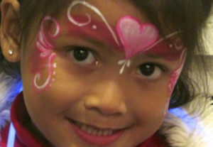 A Girls Face With a Heart in Pink Color Paint