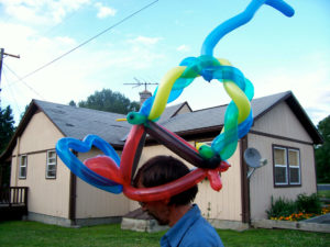 A Balloon Hat on a Man in a Blue Color SHirt