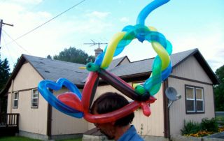 A Balloon Hat on a Man in a Blue Color SHirt