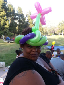 A Woman Wearing a Green and Pink Color Flower Hat