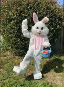 A Person in a White Bunny Costume With a Basket in Blue