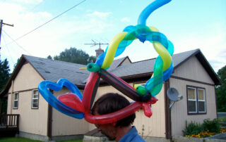 A Multi Color Balloon Hat on a Mat Head