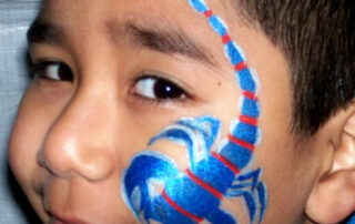 A Little Boy With a Scorpion Painting on the Face