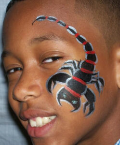 A Boy With a Black Color Scorpion on Face