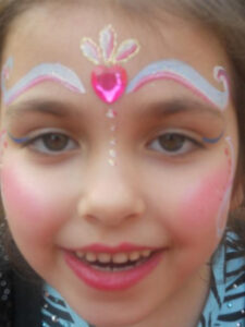 A Little Girl With a Heart Shaped Design Above the Eyes