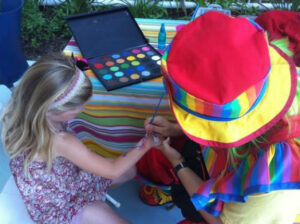 A Little Girl Getting Hand Painted by a Woman