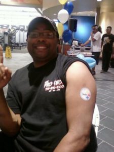A Mans Arm With a Patch in White Color With Logo