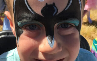 A Boy With a Batman Painting on the Face