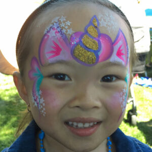 A Little Boy With a Unicorn Theme Painting on the Head
