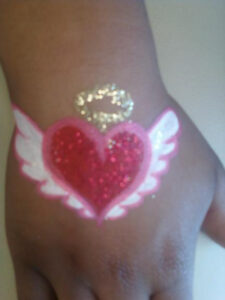 A Heart Shape Painting on Hand With Feathers
