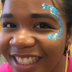 A Little Girl With a Blue Glitter Face Painting