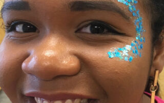 A Little Girl With a Blue Glitter Face Painting