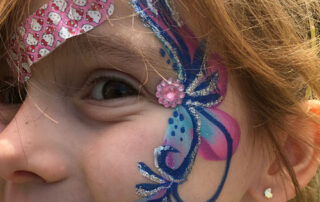 The Side of the Face of a Girl With a Butterfly Paint