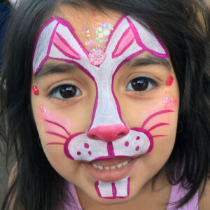 A Little Girls Face With a Bunny Shape Painting