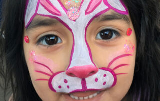 A Little Girls Face With a Bunny Shape Painting