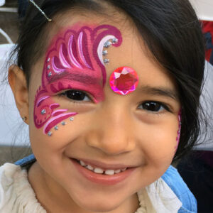 The Front of a Girls Face With a Pink Color Wing