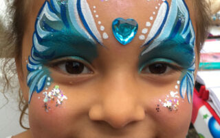 A Little Girl With Face Painting in Blue
