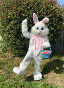 A Person in a White Bunny Costume With a Bucket